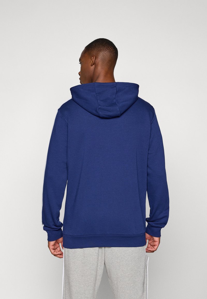 Navyblauwe hoodie met een trekkoord kap, lange mouwen en geribde boorden. Zachte stof; strakDesign zonder patronen of versieringen.