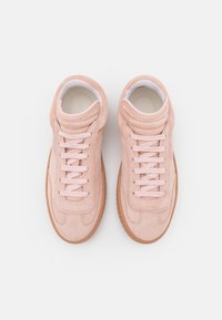 Sneaker in suede rosa chiaro con suola in gomma liscia, caratterizzati da un semplice design con lacci e supporto per la caviglia imbottito.