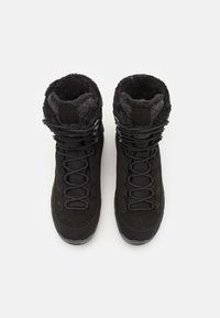 Bottes de randonnée noires avec un dessus en daim et texturé, dotées d'un col en fourrure synthétique, d'un design à lacets et d'une semelle en caoutchouc avec des motifs de traction.
