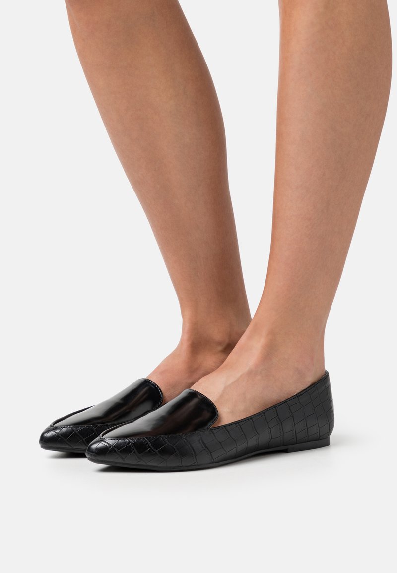 Černé ploché boty s elegantním, lesklým svrškem a krokodýlí strukturou na bocích. Nízký profil a špičatý design špičky.