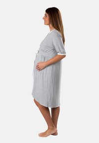 Abito da maternità grigio chiaro a maniche corte con vita legata, scollo rotondo e tessuto morbido. Presenta un sottile dettaglio arricciato sotto il seno.