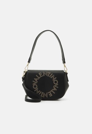 Sac en cuir noir porté épaule avec une forme incurvée, orné de clous dorés en motif circulaire et doté d'une bandoulière amovible.