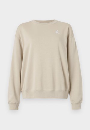 Beez värvi dressipluus, mis on valmistatud pehmest kangast, ümmarguse kaelusega, ribatud soonikuvarrukatega, laia lõikega ja vasakul rinnal valge logo.