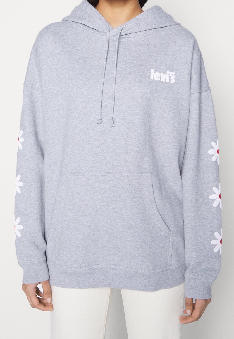 Šedá mikina s kapucí a klokaní kapsou, bílým logem "Levi's" a květinovou výšivkou v bílé a červené na rukávech. Měkká tkanina.