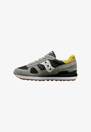 Sneaker in suede grigia e mesh con dettagli neri, caratterizzato da una striscia bianca, suola in gomma e branding giallo sul tallone.