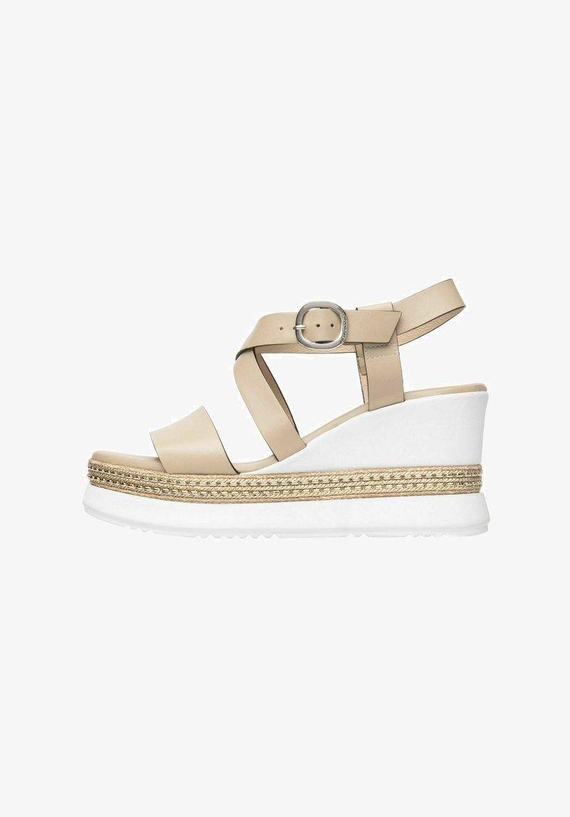 Sandale compensée en cuir beige avec des brides croisées, boucle en argent et semelle intermédiaire en jute tressé. Semelle en caoutchouc blanc épais pour une adhérence et un confort optimaux.