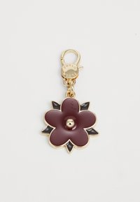 Porte-clés doré avec un charm en forme de fleur bordeaux, accentué de pétales noirs et d'un fermoir gravé "FURLA."