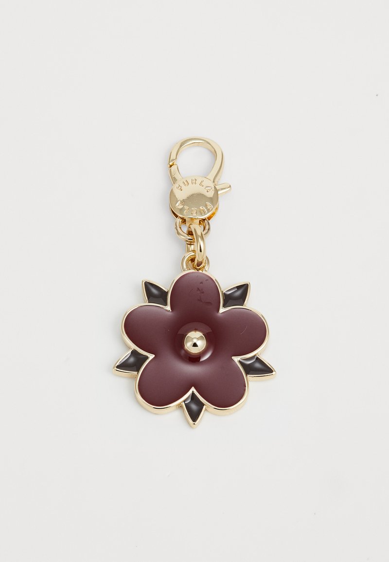 Porte-clés doré avec un charm en forme de fleur bordeaux, accentué de pétales noirs et d'un fermoir gravé "FURLA."