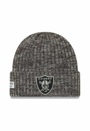 Gray knit beanie made from soft yarn, featuring a folded cuff. Displays a black and white Raiders logo on the front. Textured pattern throughout.