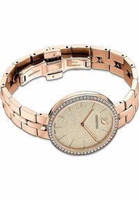 Ceas din metal roz auriu cu un finisaj lustruit, carcasă rotundă și un cadran bej texturat, accentuat de un bezel încrustat cu cristale și verigi de brățară.