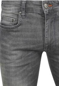Gray denim jeans with a smooth texture, five-pocket design, and contrasting orange stitching on the button fly. Features metallic hardware accents.