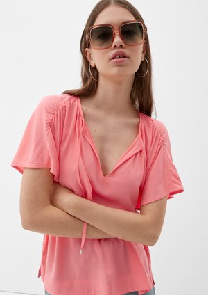 Losse, roze blouse met korte mouwen, diepe V-hals en geplooide details. Lichtgewicht stof met een gladde textuur.