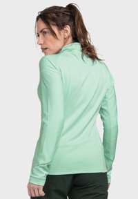 Mintgrünes Langarm-Active-Shirt mit gerippter Textur und hohem Kragen, ausgestattet mit Daumenlöchern an den Bündchen für zusätzlichen Komfort.