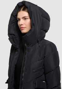 Must nööpidega sulejope suure ja vormitud kapuutsiga. Varustatud lukuga taskutega ja siledapinna ning läikiva tekstuuriga. Kinnitatakse pandlate ja lukuga.