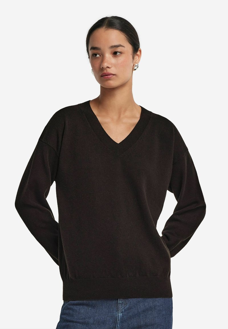 Schwarzer V-Ausschnitt-Pullover aus weichem Strickstoff mit geripptem Kragen und Bündchen. Bequeme Passform mit langen Ärmeln und gerader Säume.