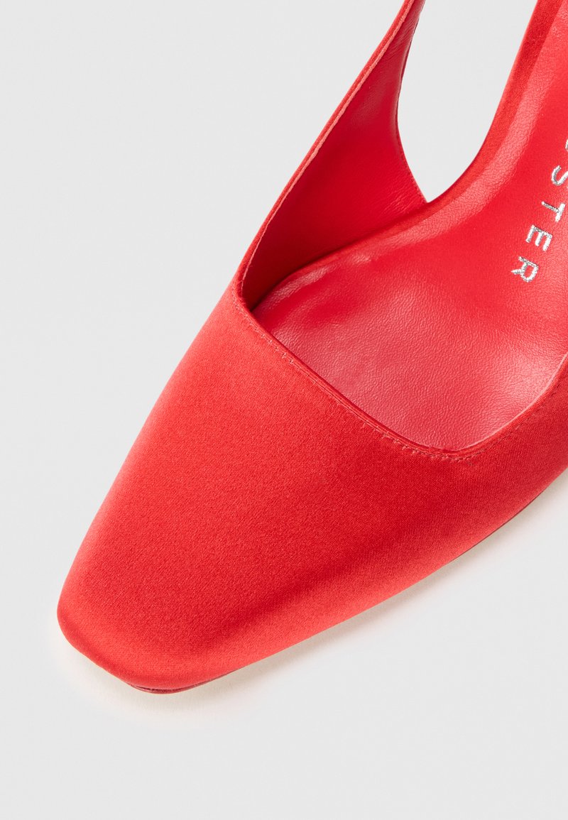 Red satin high-heeled shoe with a pointed toe and a cutout side, featuring a smooth texture and a glossy inner lining.