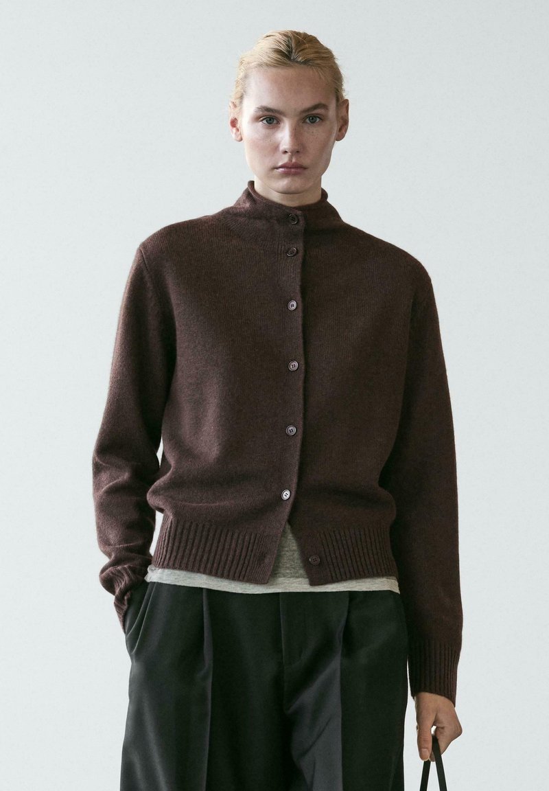 Bordeauxrode cardigan gemaakt van zachte gebreide stof, voorzien van een hoge kraag, knoopsluiting, geribbelde zoom en lange mouwen, gecombineerd met grijze lagen eronder.