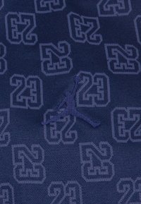 Mornarska tkanina s utisnutim uzorkom "23" i "N" različitih veličina, s izbočenim, kontrastnim Jordan logotipom.