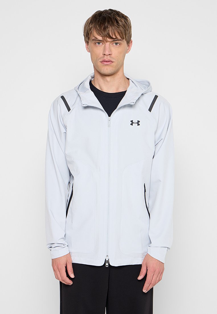 Veste à capuche gris clair avec des accents noirs, texture lisse, fermeture éclair et poches latérales, conçue pour le sport et le confort.