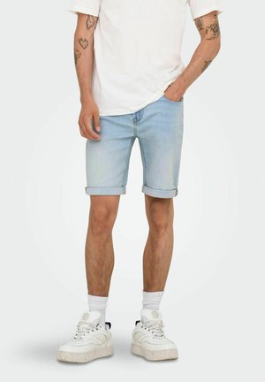 Lichtblauwe denimshorts met opgerolde zomen, gecombineerd met een witte t-shirt en witte sneakers. Heeft een losse pasvorm en een casual ontwerp.