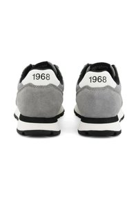 Sneaker in suede grigio con dettagli neri e linguette bianche sul tallone. Presenta la scritta "1968" stampata sul retro. Punta arrotondata e suola ammortizzata.