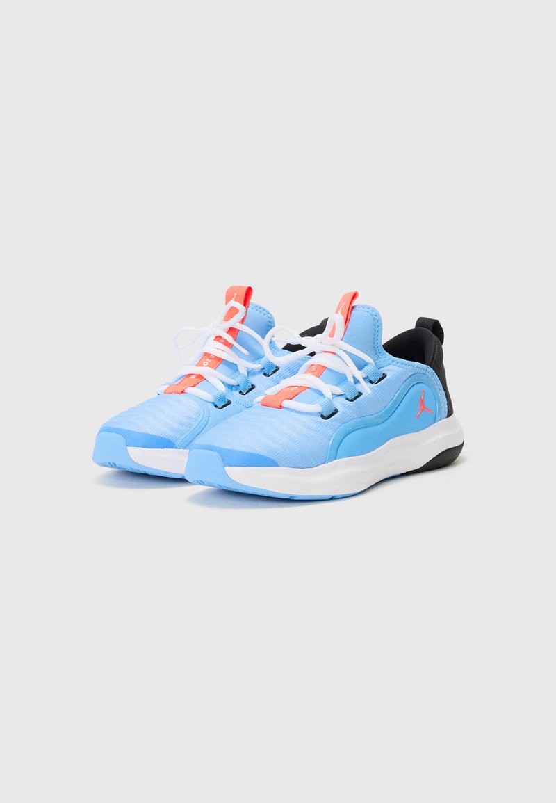 Zapatillas deportivas de color azul claro con parte superior texturizada, talón negro, suela blanca y detalles en rojo. Presentan cordones blancos y un logo en el costado.