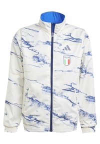 Vit sportjacka med blå marmorering. Har hög krage, frontdragkedja och Italien-logotyp. Materialet är mjukt och lätt.