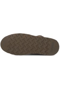 Bruine rubberen zool met zigzagpatroon, voorzien van een gestructureerde afwerking en branding. Plat ontwerp geschikt voor casual draag.
