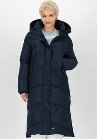 Cappotto lungo puffer blu navy con cappuccio, tasche laterali con zip e texture trapuntata. Presenta un poster con il logo vicino all'orlo. Realizzato in materiale isolante.