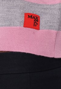 Maglione a righe rosa e grigio, texture lavorata a maglia, presenta un'etichetta rossa con il testo "MAX", polsini e orlo a coste, vestibilità casual.