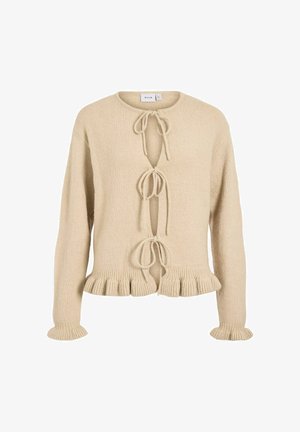Beige knitted cardigan with long sleeves, tie closures at the front, and a ruffled hem and sleeve cuffs. Soft texture, casual design.