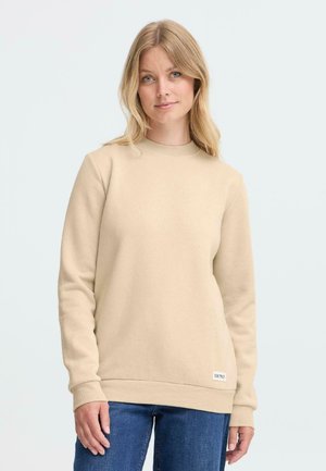 Felpa beige con maniche lunghe e scollatura rotonda. Presenta polsini e orlo ribattuti, una texture morbida e una piccola etichetta del marchio nella parte inferiore.