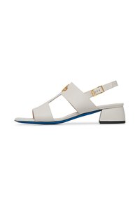 Sandal in pelle bianca con design aperto alla punta, caratterizzato da ritagli, accessori in oro, cinturino regolabile e un basso tacco a blocco blu e nero.