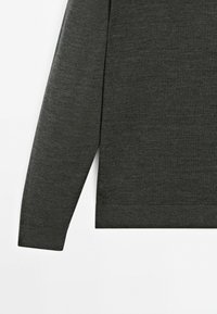 Mörkgrå långärmad topp med rak nederkant och ribbmuddar, tillverkad av mjukt tyg med en slät yta.