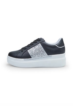 Zwarte leren sneaker met een zilveren glitterschouder, dikke witte zool, zwarte veters en zilveren accenten op de hak en zijkanten.