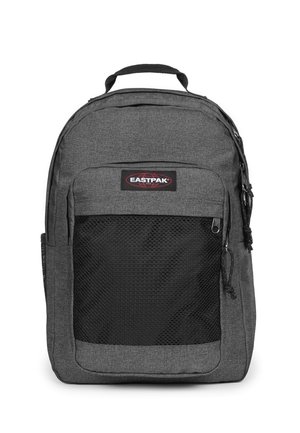 Mochila de tela gris con un bolsillo delantero de malla negra, doble cremallera y un asa en la parte superior para llevar. Logotipo visible en la parte frontal.