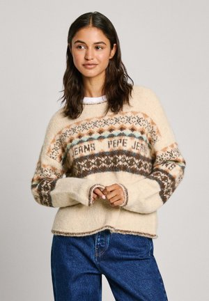 Crème-kleurige gebreide trui met een patronen yoke in bruin, teal en oranje. Heeft geribbelde manchetten en een losse pasvorm. Gecombineerd met blauwe jeans.