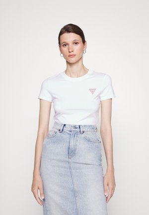 Tricou alb din bumbac cu mâneci scurte, având un logo triunghiular roșu pe partea stângă a pieptului, asortat cu o fustă din denim de culoare albastru deschis.