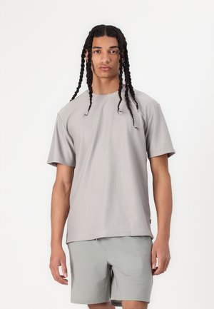 Grå ribbet T-shirt med kortærmer og rund hals, parret med lysegrå shorts. Har en afslappet pasform og blødt, tekstureret stof.