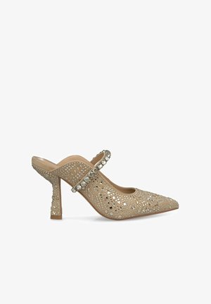 Beige Slingback-Absatzschuh mit spitz zulaufender Zehenpartie, verziert mit Strasssteinen und Nieten, ausgestattet mit einem dekorativen Träger und strukturierten Seiten.