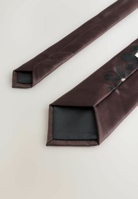 Two dark brown satin ties with a textured black interior. One tie features a floral design in shades of gray and black. Angular tips.
