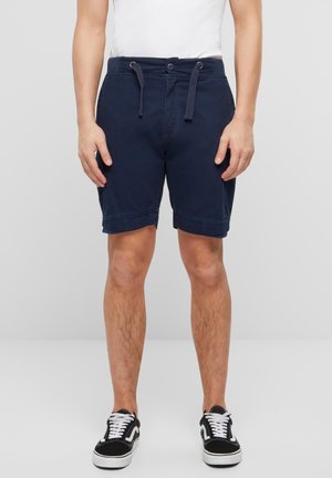 Pantaloni corti blu navy con vita regolabile in corda, orlo arrotolato e tasche laterali. Realizzati in cotone con una texture morbida e leggera.