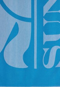 Un tessuto blu con un grande design di lettere stilizzate bianche caratterizzato da linee morbide e fluide e da sfumature di blu sullo sfondo.