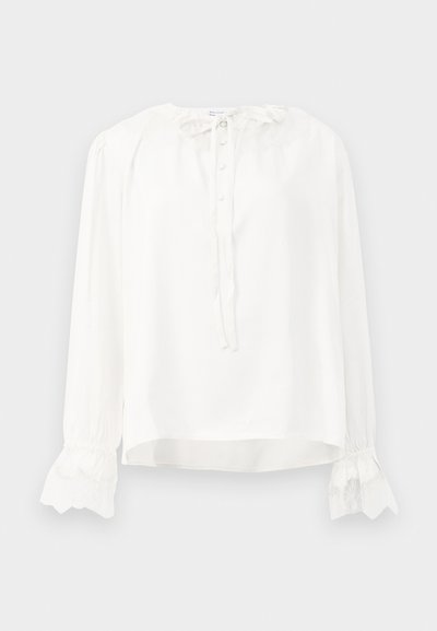 Weiße Bluse mit langen Ärmeln aus glattem Stoff, versehen mit einem runden Halsausschnitt, Knopfverschluss und Spitzenbesatz an den Säumen. Mit einer Krawatte am Hals verstellbar.
