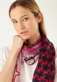 Écharpe multicolore avec un motif paisley rose et des accents étoilés rouges. Légère, avec une texture douce, drapée autour du cou.