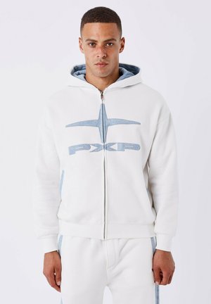 Felpa bianca con zip e logo blu, dotata di cappuccio foderato in denim e tasche laterali. Realizzata in tessuto morbido con polsini e orlo a costine.