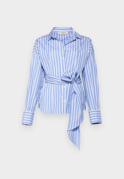 Lichtblauw langemouwen shirt met verticale witte strepen, voorzien van een geknoopte taille en knoopsluiting, gemaakt van een zachte stof.