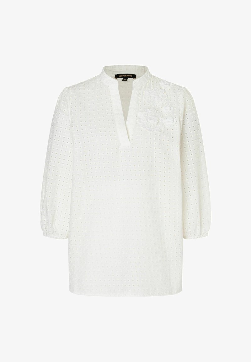 Weiße Bluse mit V-Ausschnitt, puffigen Ärmeln und gestickten floralen Details. Aus strukturiertem Stoff mit Lochmuster gefertigt.
