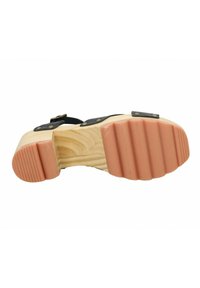 Sandale noire avec plateforme en bois. Semelle extérieure texturée et rainurée en brun clair. Accents métalliques et sangles pour un ajustement sécurisé. Grain de bois lisse visible.