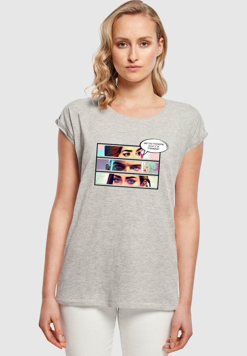 Lys grå bomulds t-shirt med rulleærmer, der har et tegneserie-lignende grafisk motiv af tre øjne og en tale-boble med tekst.